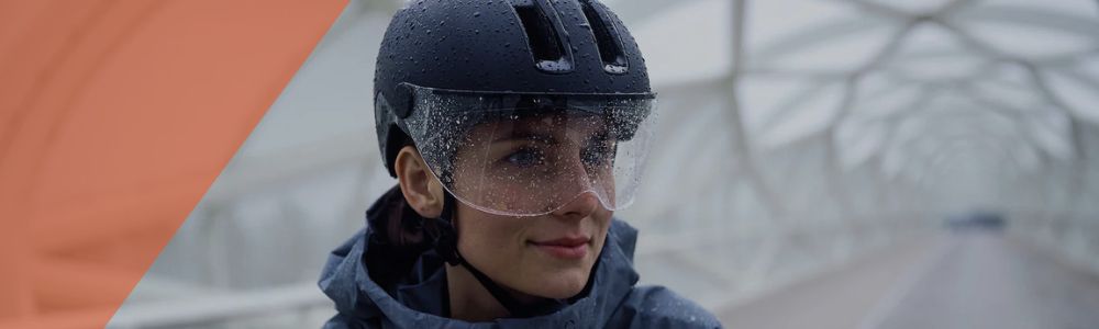 "Casque vélo ville avec visière transparente porté sous la pluie"